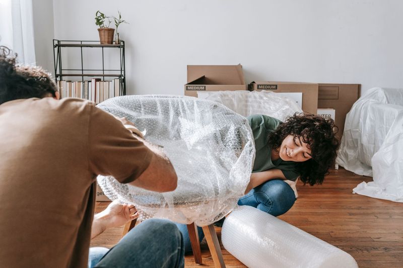 Professional Phoenix movers carrying a sofa carefully through a residential doorway