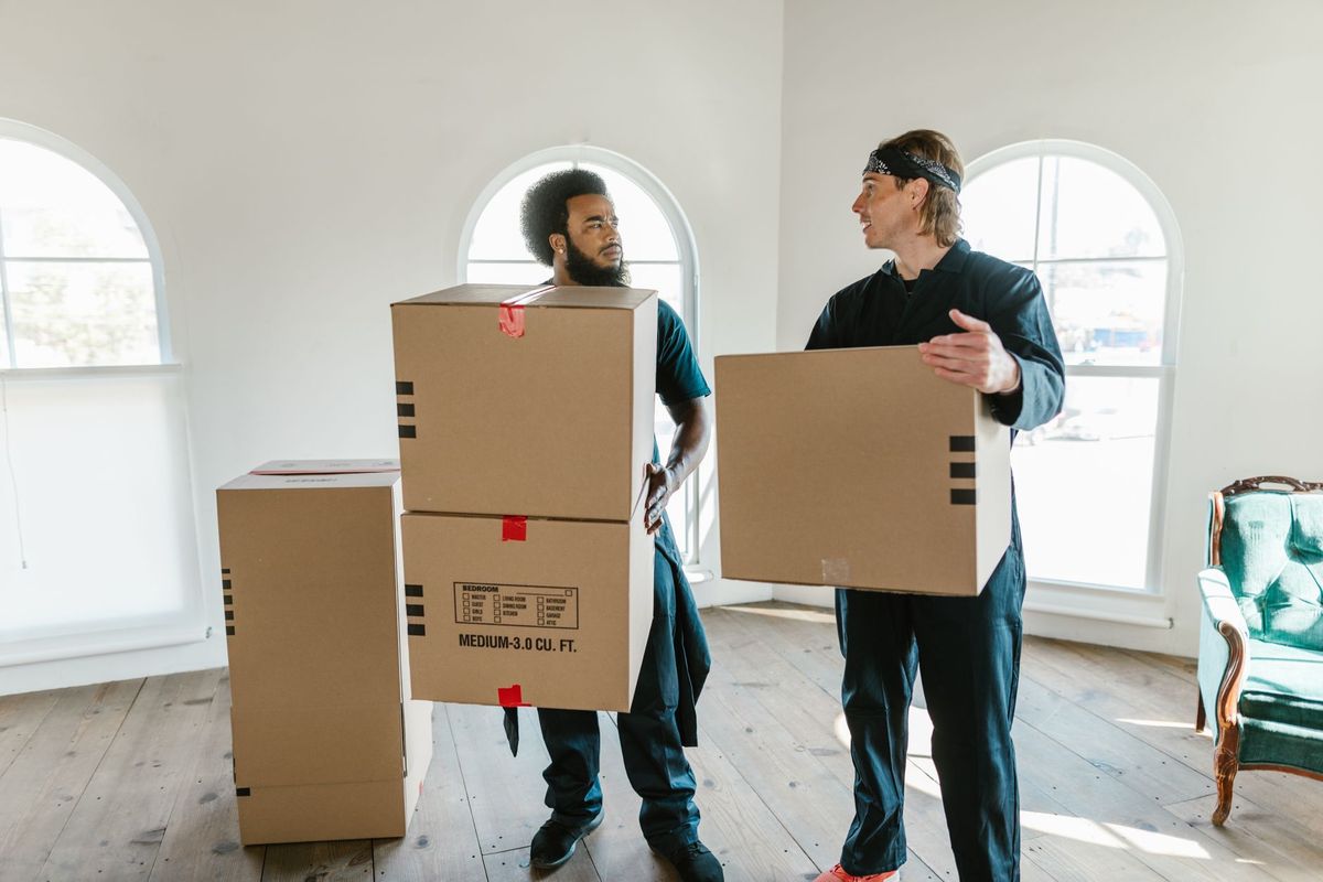 Office movers carefully carrying desks and equipment during a Phoenix workplace relocation