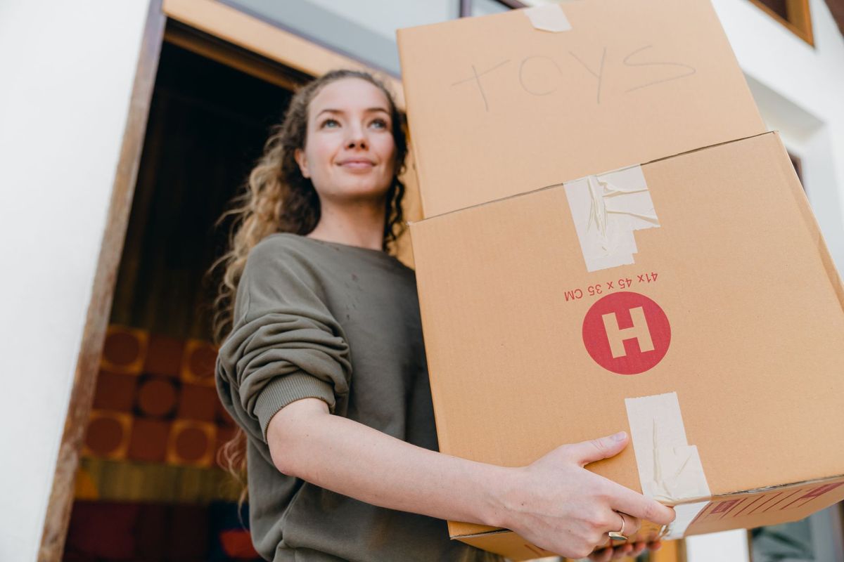 Professional movers packing kitchen items into labeled moving boxes in Phoenix