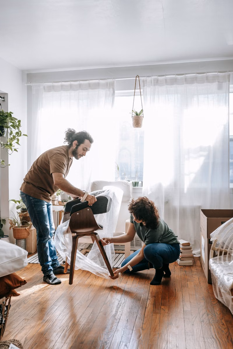 Mover wrapping a dining table before a Phoenix relocation